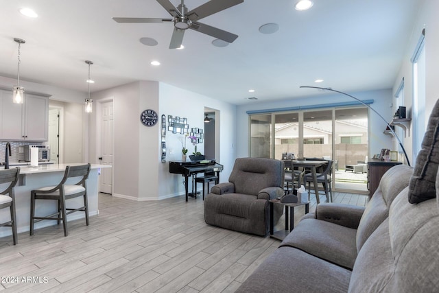 living room featuring ceiling fan and light wood-type flooring