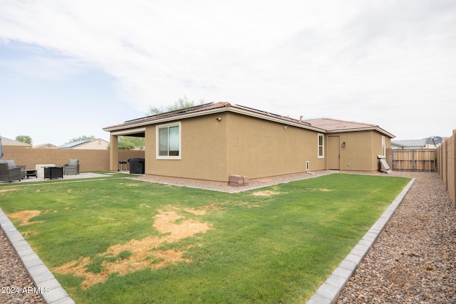 back of house with cooling unit, a lawn, and a patio