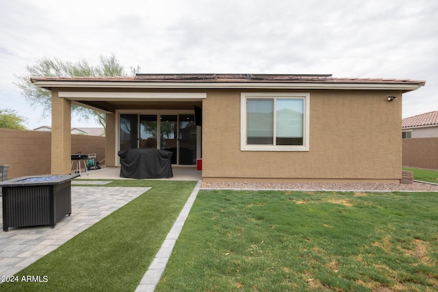 rear view of property with a yard and a patio area