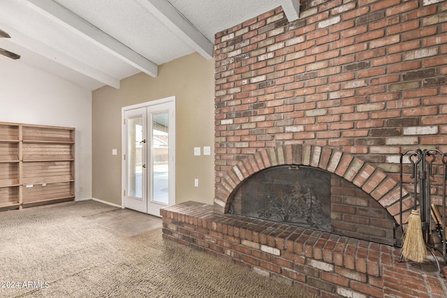 unfurnished living room with french doors, vaulted ceiling with beams, a textured ceiling, a fireplace, and dark carpet