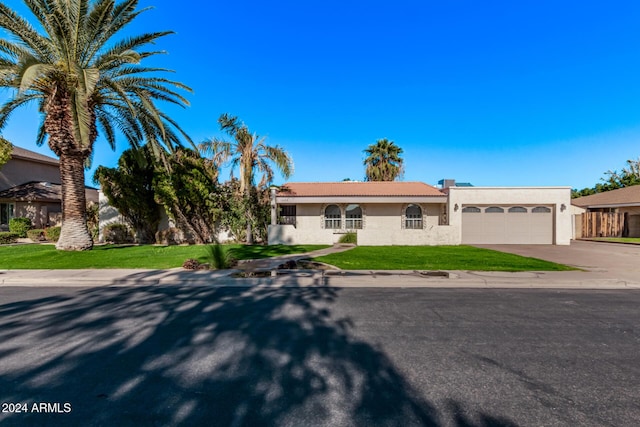 view of front of home with a front yard and a garage