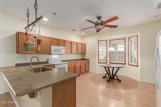 8256 W Bloomfield Rd, Peoria, AZ 85381 - kitchen with white appliances, a sink, a peninsula, brown cabinets, and a ceiling fan