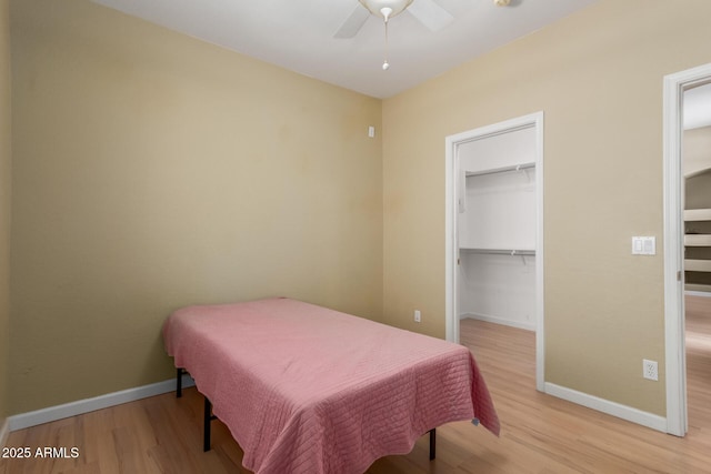 8256 W Bloomfield Rd, Peoria, AZ 85381 - bedroom featuring light wood-style flooring, baseboards, a walk in closet, and a ceiling fan