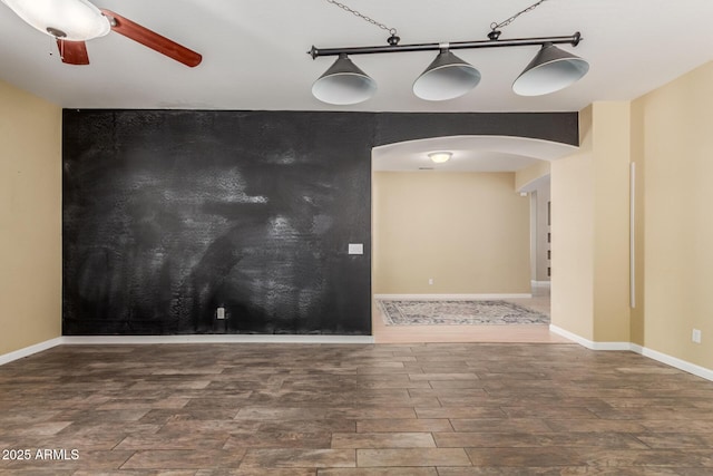 8256 W Bloomfield Rd, Peoria, AZ 85381 - unfurnished room with arched walkways, wood finished floors, a ceiling fan, and baseboards