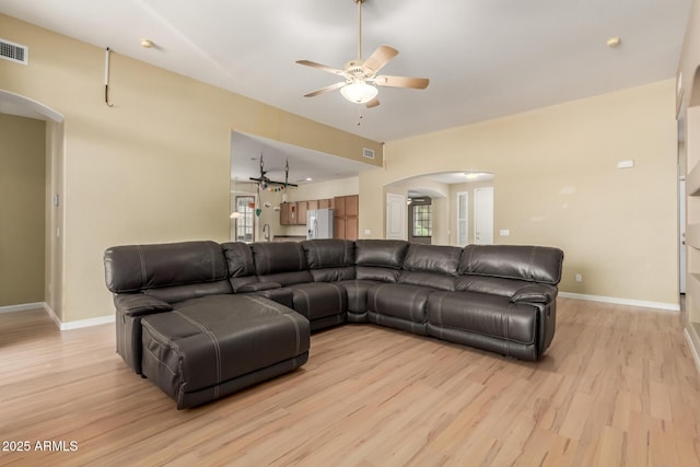 8256 W Bloomfield Rd, Peoria, AZ 85381 - living room featuring arched walkways, ceiling fan, light wood-style floors, and healthy amount of natural light