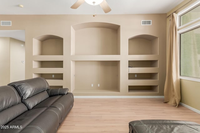 8256 W Bloomfield Rd, Peoria, AZ 85381 - living area featuring built in shelves, wood finished floors, a ceiling fan, and baseboards