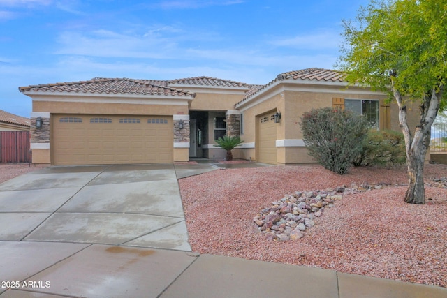 view of front of home with a tiled roof, a garage, concrete driveway, and stucco siding