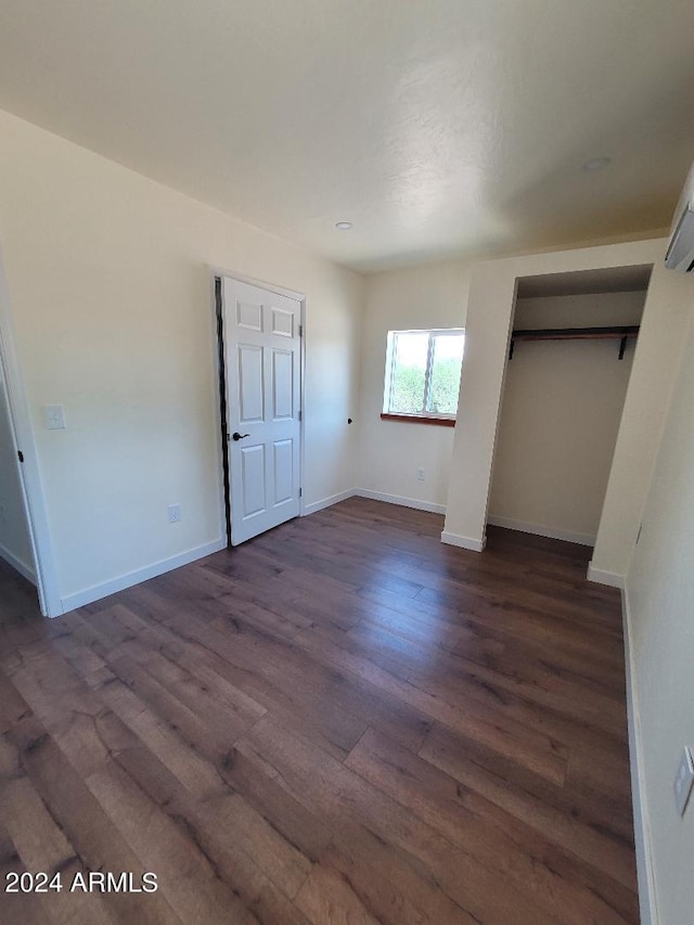 unfurnished bedroom featuring dark hardwood / wood-style floors and a closet