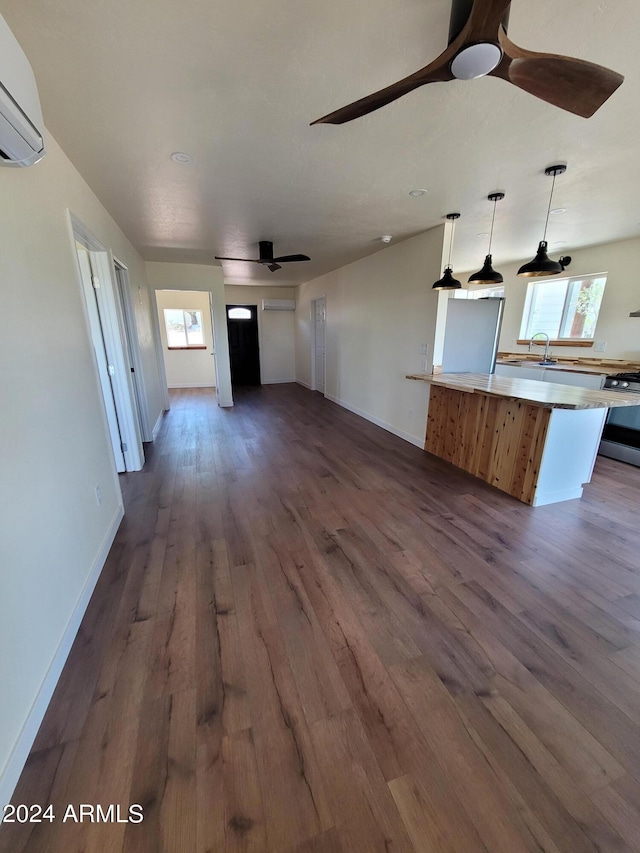 unfurnished living room featuring hardwood / wood-style flooring, a wealth of natural light, and ceiling fan