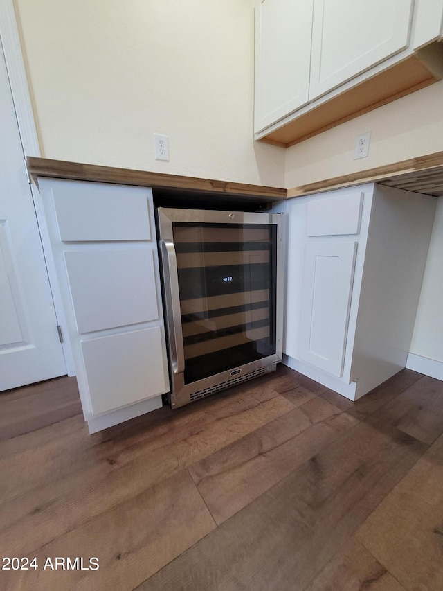 interior space with wine cooler, white cabinetry, and dark hardwood / wood-style floors