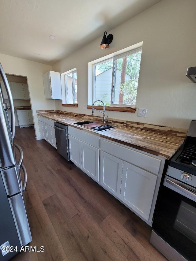 kitchen with dark hardwood / wood-style floors, white cabinetry, sink, butcher block counters, and stainless steel appliances