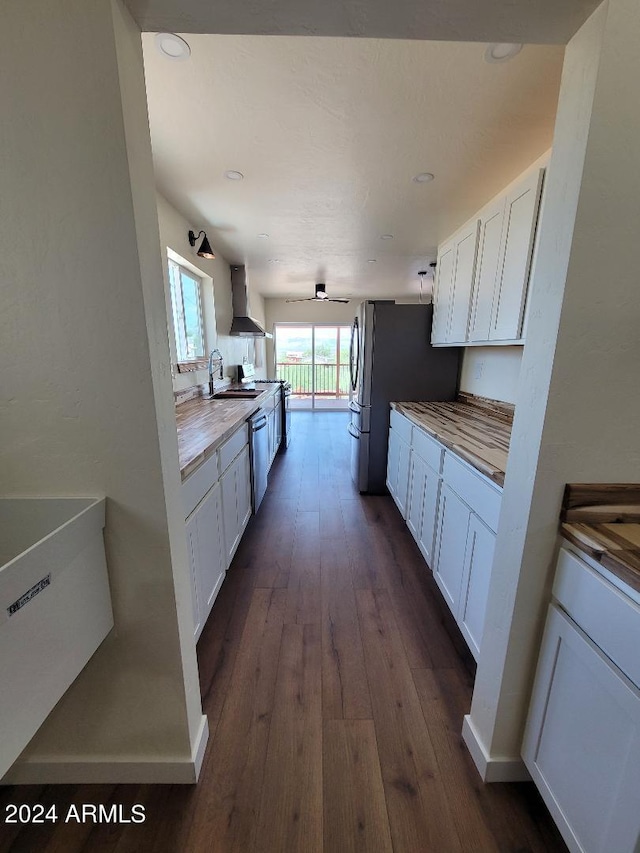 kitchen with white cabinetry, sink, wall chimney range hood, and stainless steel dishwasher