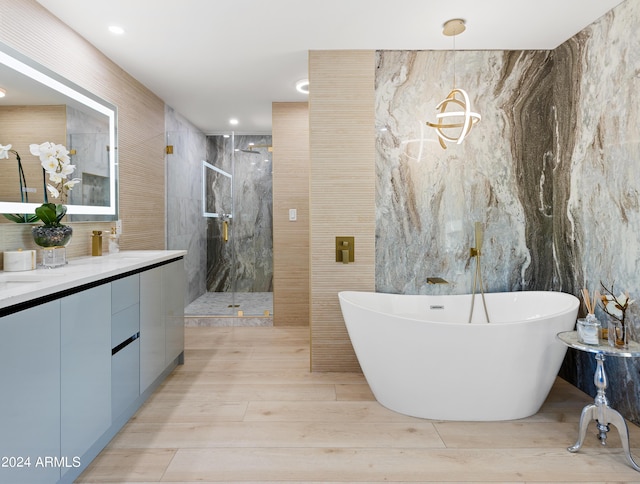 bathroom with tile walls, vanity, independent shower and bath, and hardwood / wood-style flooring