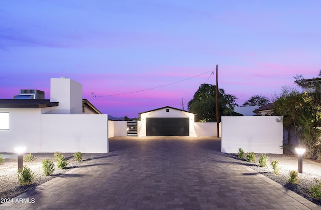 garage at dusk featuring central AC unit