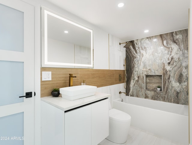 full bathroom featuring tile walls, toilet, vanity, and tiled shower / bath