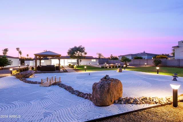 pool at dusk with a patio area, a gazebo, and an outdoor hangout area