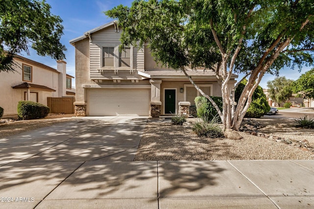 6962 W Glenn Dr, Glendale, AZ 85303 - view of front of house with driveway, an attached garage, stone siding, and stucco siding