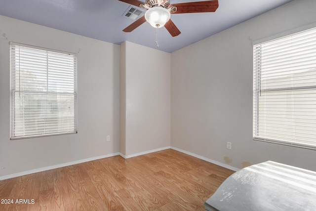 bedroom featuring ceiling fan, light hardwood / wood-style floors, and multiple windows