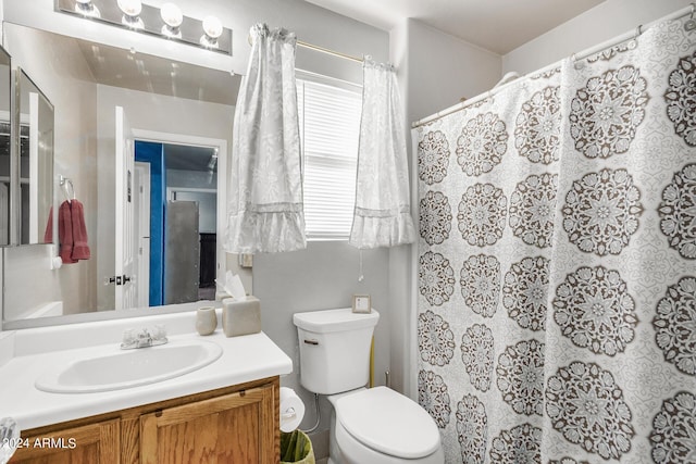 bathroom featuring toilet, a healthy amount of sunlight, vanity, and a shower with shower curtain