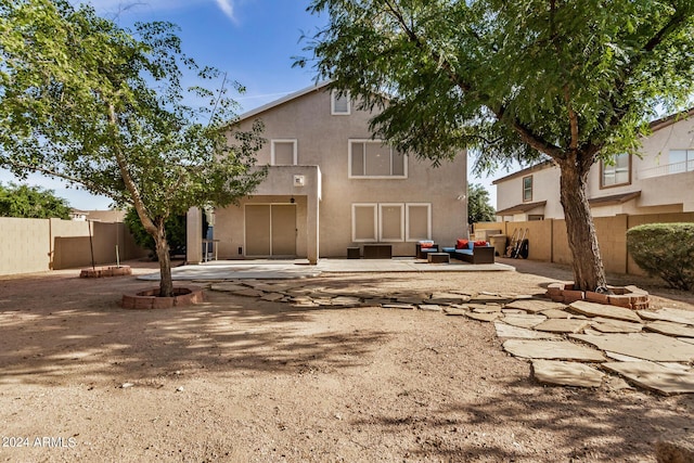 back of house with a patio area and an outdoor living space