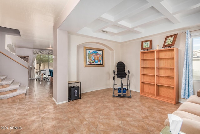 interior space featuring light tile patterned floors, a wealth of natural light, beam ceiling, and coffered ceiling