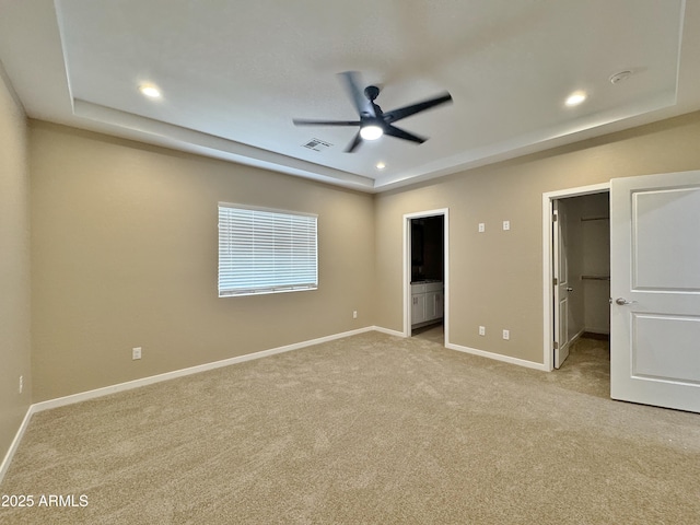 15422 S Sequoia Cir, Arizona City, AZ 85123 - unfurnished bedroom with light carpet, a walk in closet, visible vents, and a tray ceiling