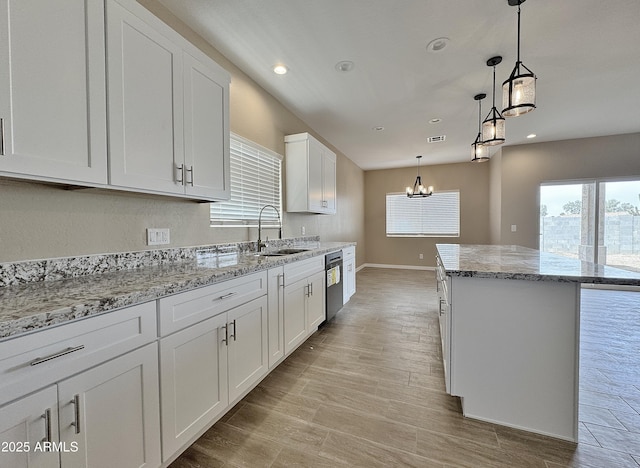 15422 S Sequoia Cir, Arizona City, AZ 85123 - kitchen with white cabinets, a notable chandelier, a sink, stainless steel dishwasher, and a kitchen island