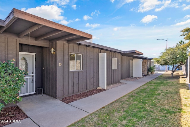 property entrance with a lawn