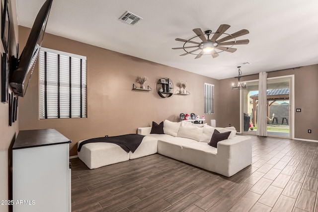 living room featuring ceiling fan with notable chandelier