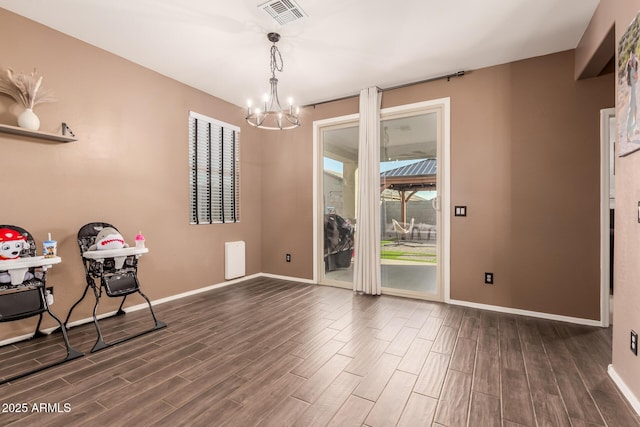 unfurnished dining area featuring a chandelier and dark hardwood / wood-style flooring