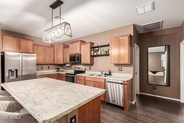 kitchen with sink, a center island, pendant lighting, a kitchen breakfast bar, and stainless steel appliances