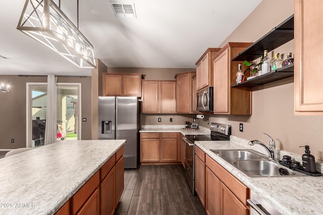 kitchen with appliances with stainless steel finishes, decorative light fixtures, sink, and dark hardwood / wood-style floors