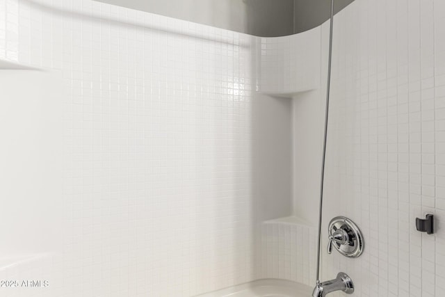 interior details featuring tiled shower / bath