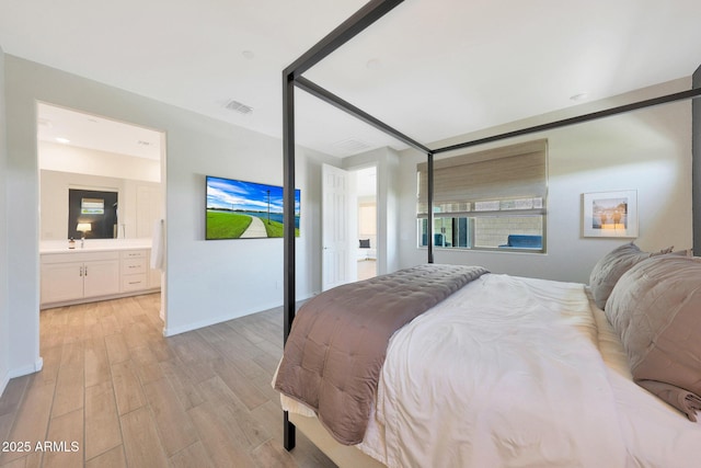 29339 N 135th Dr, Peoria, AZ 85383 - bedroom featuring light wood-style floors, baseboards, ensuite bathroom, and a sink
