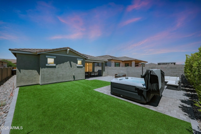 29339 N 135th Dr, Peoria, AZ 85383 - back of house at dusk with a hot tub, a patio area, and stucco siding