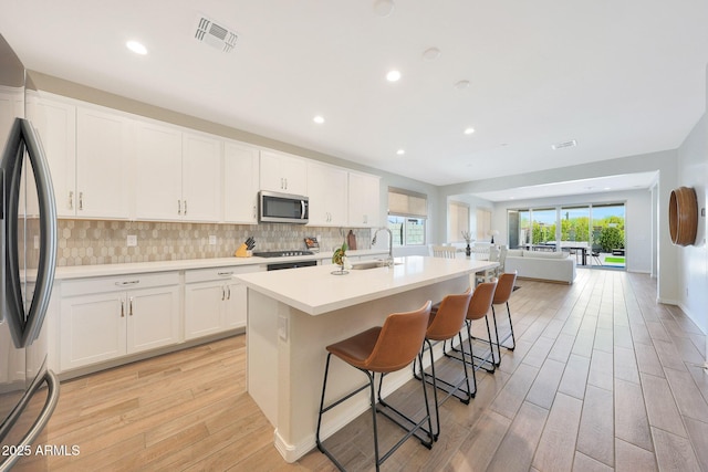 29339 N 135th Dr, Peoria, AZ 85383 - kitchen featuring appliances with stainless steel finishes, light wood finished floors, white cabinetry, and recessed lighting