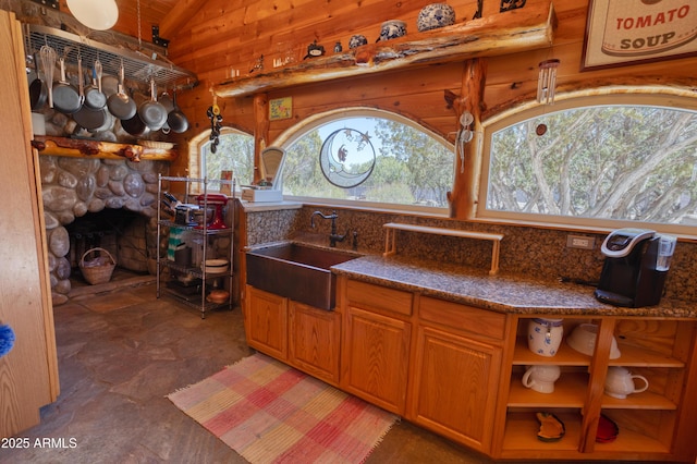 8455 Ridge Dr, Show Low, AZ 85901 - kitchen with a sink, wood walls, vaulted ceiling, dark stone countertops, and light stone finish flooring