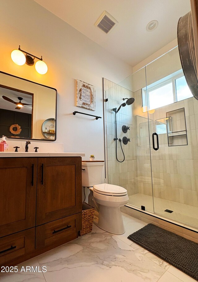 full bathroom featuring toilet, marble finish floor, visible vents, a shower stall, and vanity