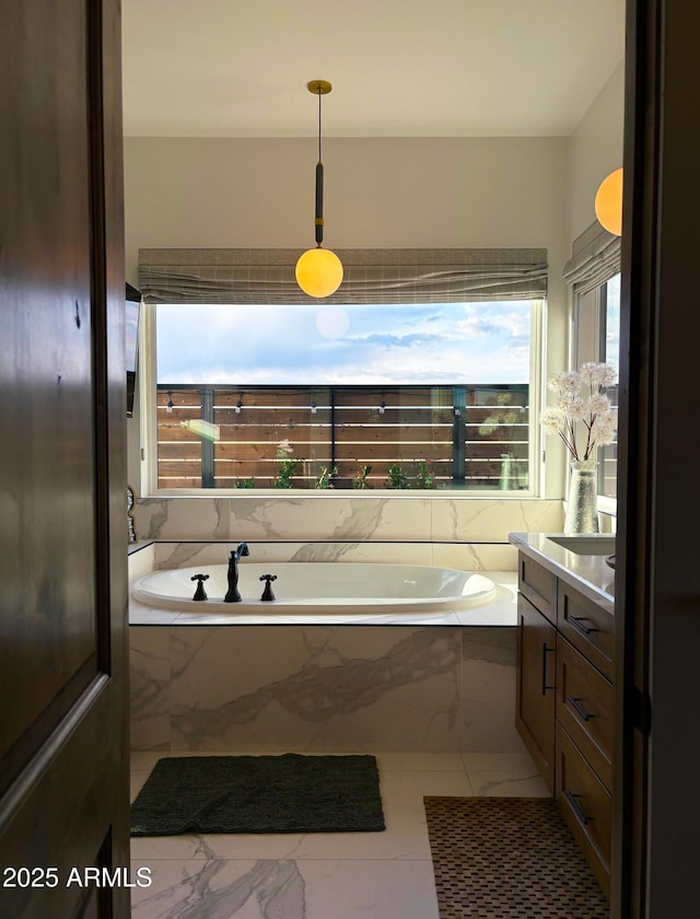 full bath with marble finish floor, a garden tub, vanity, and plenty of natural light