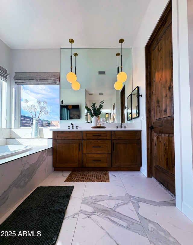 bathroom with marble finish floor, visible vents, a sink, a garden tub, and double vanity