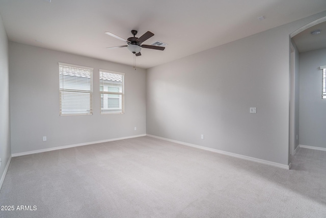 spare room with visible vents, ceiling fan, light carpet, and baseboards