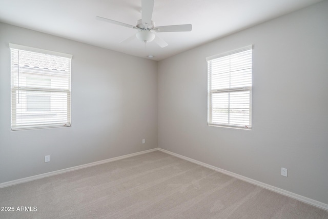 unfurnished room featuring baseboards, a ceiling fan, and light colored carpet