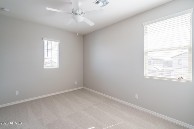unfurnished room featuring a ceiling fan, light colored carpet, visible vents, and baseboards