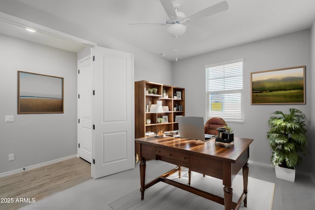 office space with ceiling fan and baseboards