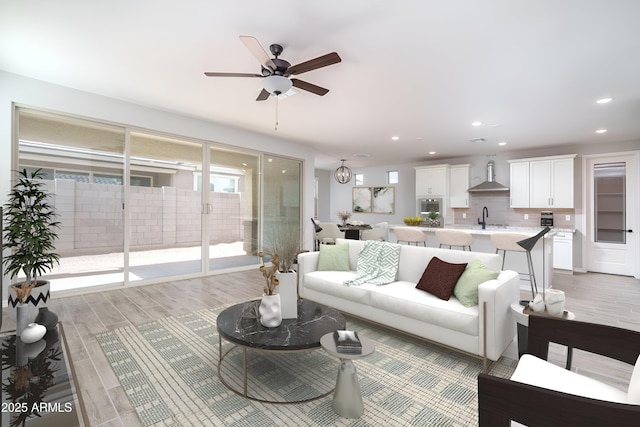 living room featuring a ceiling fan, recessed lighting, and light wood-style flooring