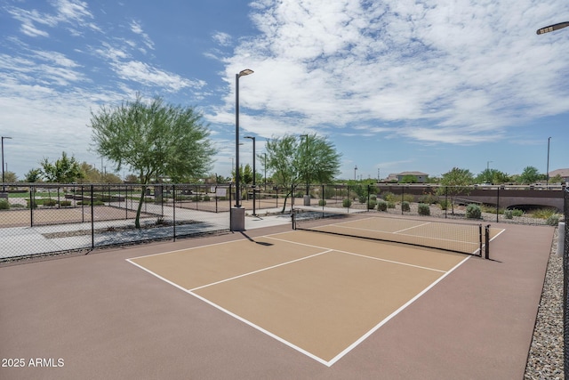 view of tennis court with community basketball court and fence