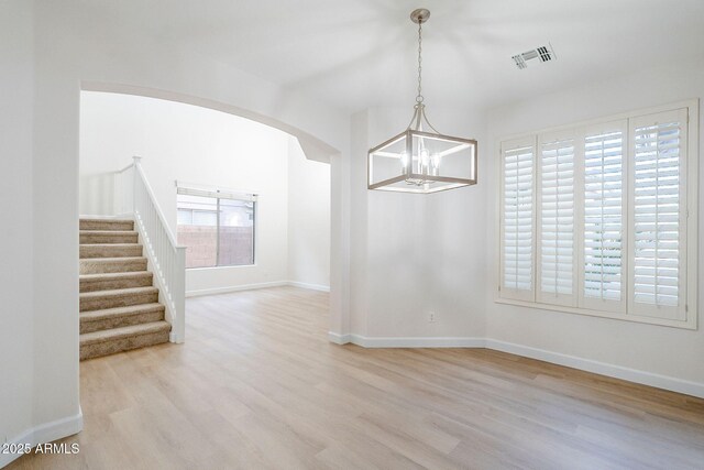 4389 E Muirfield St, Gilbert, AZ 85298 - unfurnished dining area with a notable chandelier, baseboards, stairs, visible vents, and wood finished floors