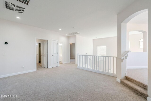 4389 E Muirfield St, Gilbert, AZ 85298 - empty room featuring light carpet, arched walkways, visible vents, and recessed lighting