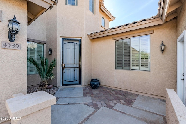 4389 E Muirfield St, Gilbert, AZ 85298 - doorway to property featuring a patio area, a tile roof, and stucco siding