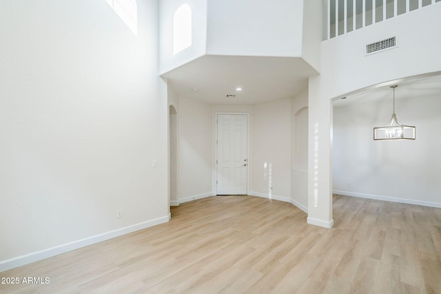 4389 E Muirfield St, Gilbert, AZ 85298 - foyer featuring baseboards, light wood-style flooring, a high ceiling, visible vents, and arched walkways